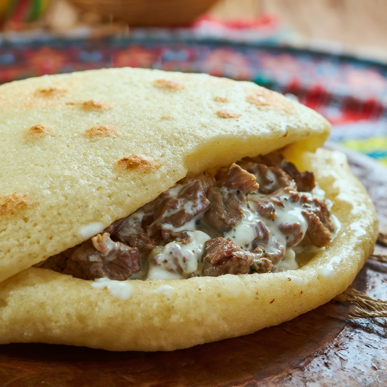 Arepa de Tavë Kosi: Fusión de Kosovo y Venezuela